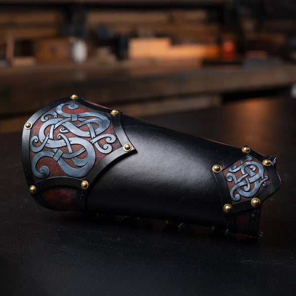 Decorative leather arm guard with intricate patterns on a dark background